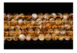 Macro detail view of polished yellow citrine crystal beads with internal textures