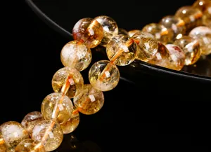 Macro view of natural yellow citrine beads showing internal ice crack textures for DIY