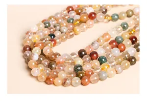 Macro detail of mixed colorful natural rutilated quartz round beads for DIY jewelry.