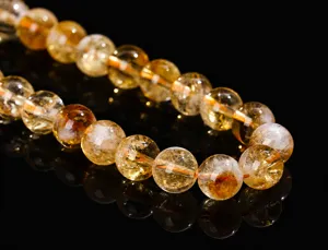 Macro view of polished yellow citrine crystal beads showcasing natural internal textures