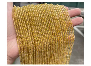 Macro detail of 3mm natural golden rutilated quartz round loose beads for DIY jewelry