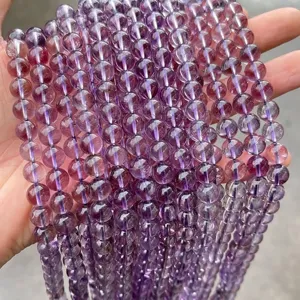 Detailed view of translucent natural purple amethyst round beads for jewelry making.
