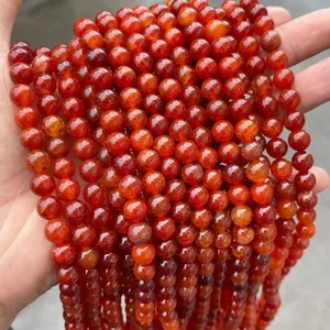 Close-up of red dragon vein agate beads with unique crackle texture for jewelry.