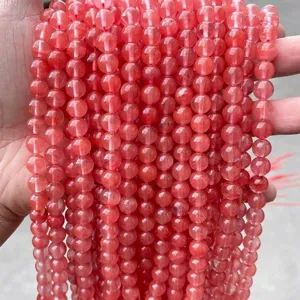 Macro view of synthetic watermelon red quartz round beads for DIY jewelry making.