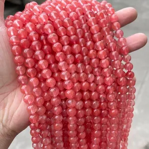 Macro detail of watermelon red round synthetic crystal beads for DIY jewelry making.