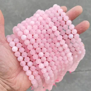 Détail de près des perles rondes en quartz rose naturel dépoli pour la création de bijoux