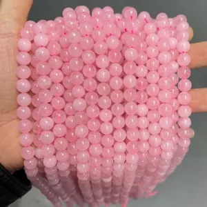 Vue détaillée de perles rondes en quartz rose naturel pour la création de bijoux DIY.
