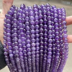 Close-up details of natural purple amethyst round loose beads for DIY jewelry making.