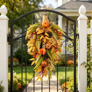 Decoración otoñal colgante con calabazas y bayas artificiales en una puerta negra.