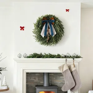 Detail van kerstkrans van Norfolk-den met blauwe strik en bellen boven de open haard