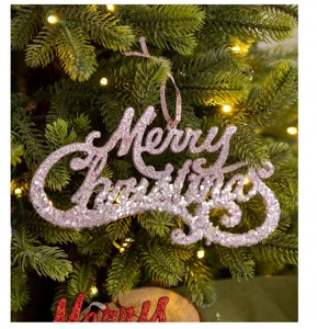 Nahaufnahme des glitzernden rosa Merry Christmas Hängeschilds am grünen Weihnachtsbaum.