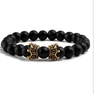 Bracelet de perles en pierre volcanique noire mate avec breloques couronne dorée, vue détaillée.