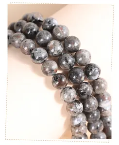 Detailed macro shot of natural flame stone round beads featuring grey mineral textures