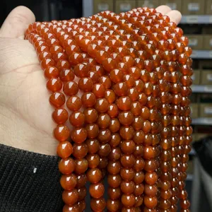 Close-up of polished translucent red agate round beads for DIY jewelry and bracelet making