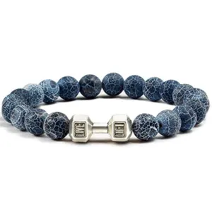Close-up van blauwe gebarsten steen kralen armband met motiverende halter bedel detail.