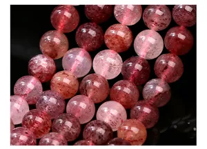 Macro view of natural strawberry quartz beads showing unique internal speckled textures.