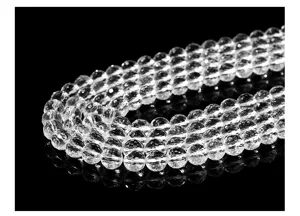 Detalle macro de cuentas de cuarzo transparente con 128 facetas para joyería DIY