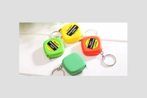 Detail view of colorful mini tape measure keychains, portable 1m measuring tool set.
