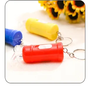 Dettaglio portachiavi torcia LED mini estintore, ciondolo novità colorato e portatile utile.