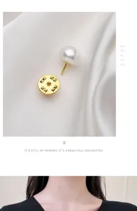 Pearl anti-glare brooch detail, elegant white pearl with gold pin for shirt collar fixing.