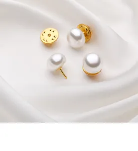 Close-up detail of white pearl anti-glare brooch pin with gold metal base for shirt collar.