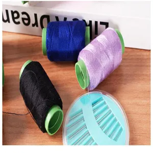 Close-up detail shot of colorful sewing thread spools and needle box on wooden background.