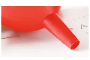 Dettaglio ravvicinato di imbuto in plastica rossa per utensile dosatore di liquidi.