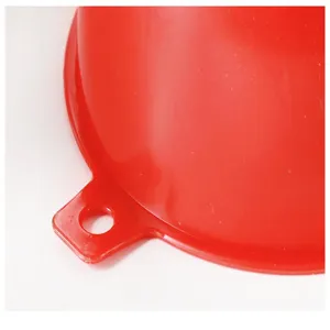 Primo piano dettagliato di un imbuto in plastica rossa con foro per olio da cucina.