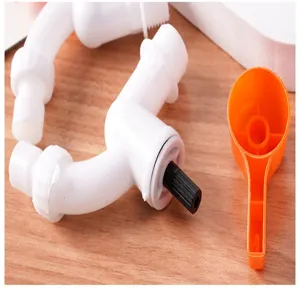 Detail shot of white plastic faucet valve accessory and orange wrench on wooden surface.