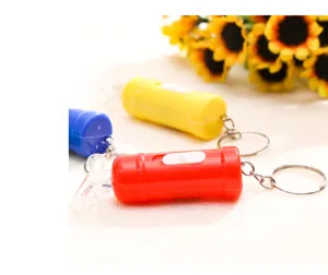 Dettaglio portachiavi LED mini estintore lampeggiante, accessorio pendente creativo portatile.
