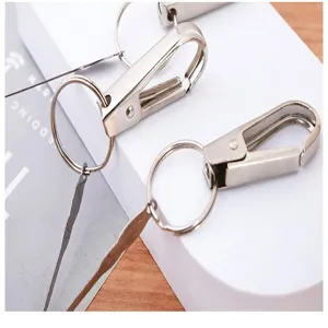 Detail view of portable metal ear pick keychain, durable stainless steel key ring pendant.