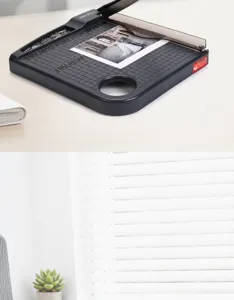 Portable A4 paper trimmer detail view with measurement grid, safety bar and storage slot.