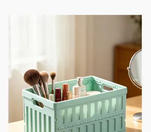 Detail view of the collapsible mint green plastic storage basket filled with makeup brushes and cosmetics.