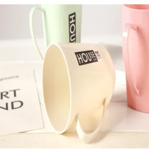 Close-up detail of simple plain plastic mouthwash cups in beige, pink, and green colors.