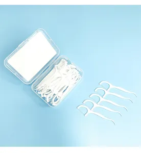 Detail view of portable dental floss picks box and individual flossers, clean oral care setup.