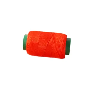 Red sewing thread spool for home hand and machine repair tailoring craft projects.