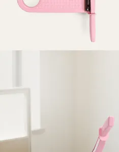 Portable A4 paper trimmer detail view, pink guillotine cutter with integrated safety baffle.