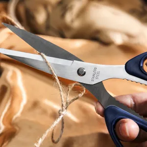 Multipurpose stainless steel household scissors cutting rope in practical everyday use view.