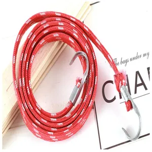 Vue détaillée de la corde élastique rouge pour bagages avec crochets métalliques de fixation.