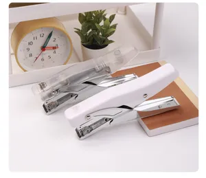 Close-up detail shot of mini hand-held staplers in clear and white finishes, desktop stationery.