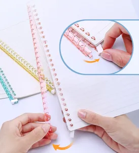 Detail shot of plastic loose leaf binder ring notebook coil binding mechanism operation.