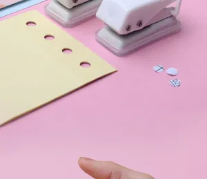Mini single hole punch for paper loose-leaf binding, portable student stationery tool.