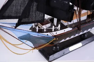 Wooden pirate ship model detail view, Mediterranean style sailboat ornament for home office decor.