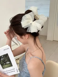 Gros plan d'une pince à cheveux élégante en tulle blanc avec perles sur modèle