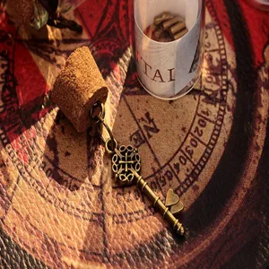 Détail pendentif clé bouteille de souhait vintage, clé en bronze avec bouchon sur carte rétro.