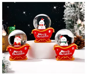 Weihnachtsschneekugel Ornament mit niedlichem Schneemann und Weihnachtsmann Schlitten. Detail.