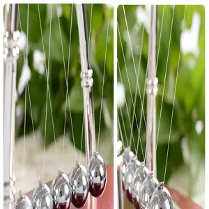 Close-up detail of silver metal Newton cradle balls, smooth swinging motion desk toy display.