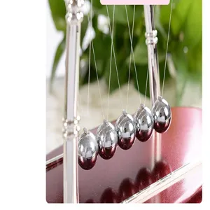Close-up detail of Newton cradle balance balls metal physics pendulum office desk decor toy