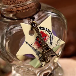 Heart shaped glass wishing bottle with Eiffel Tower charm and star tag for birthday gift.
