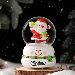 Christmas snow globe decoration featuring Santa Claus inside and snowman base with festive design.